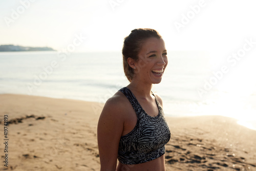 Laughing woman in bra on beach photo