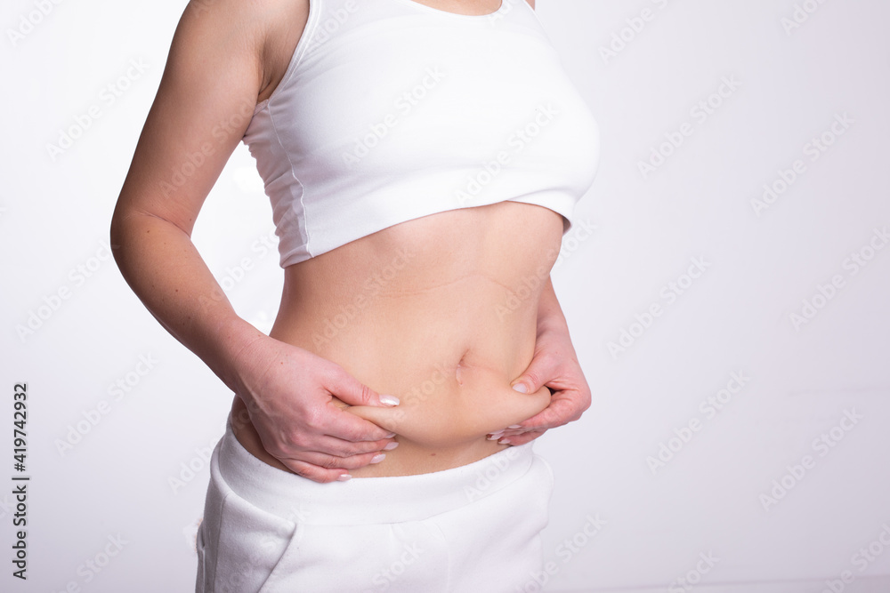 A woman using pinch test as one of the methods for measuring body fat A woman using pinch test as one of the methods for measuring body fat