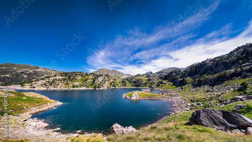 panoramic view of a glacial lake with the mountains in the background, Estany de Sant Maurici, Aigüestortes Park, Lérida, Spain