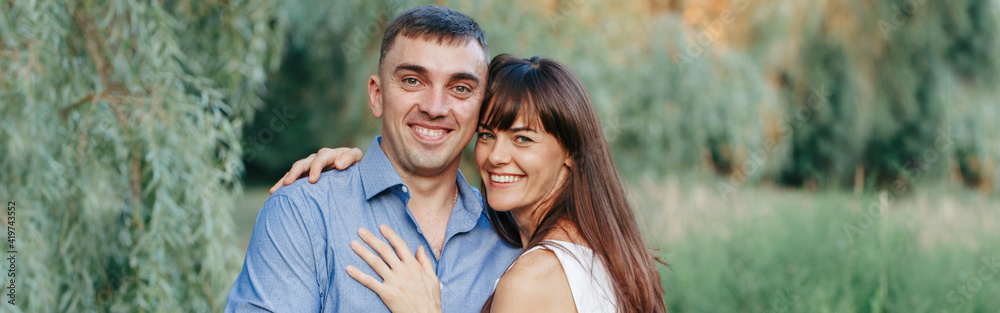 Beautiful smiling couple man woman in love. Husband and wife hugging in park on summer day. Togetherness and happiness. Authentic real people family outdoors. Web banner header. Beautiful smiling couple man woman in love. Husband and wife hugging in park on summer day. Togetherness and happiness. Authentic real people family outdoors. Web banner header.