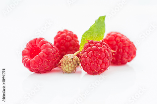 Ripe raspberry with leaves isolated on white background