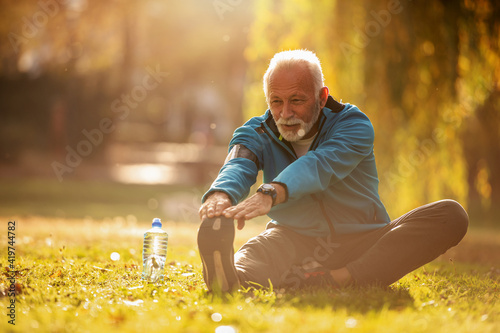 Senior man stretching in the park photo