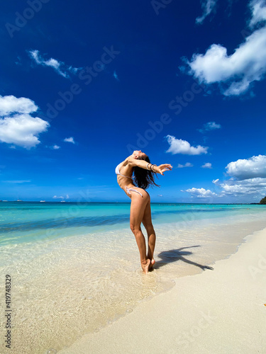 Sexy beautiful caucasian woman posing in white bikini at the sea coast. Exotic country travel and rest concept. Slim figure and sexy body