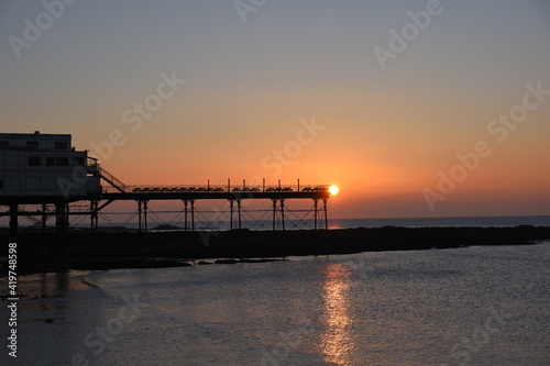 a view of the sun setting behind Aberystwyth pier 