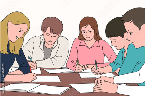 Students are sitting around a table and studying together.