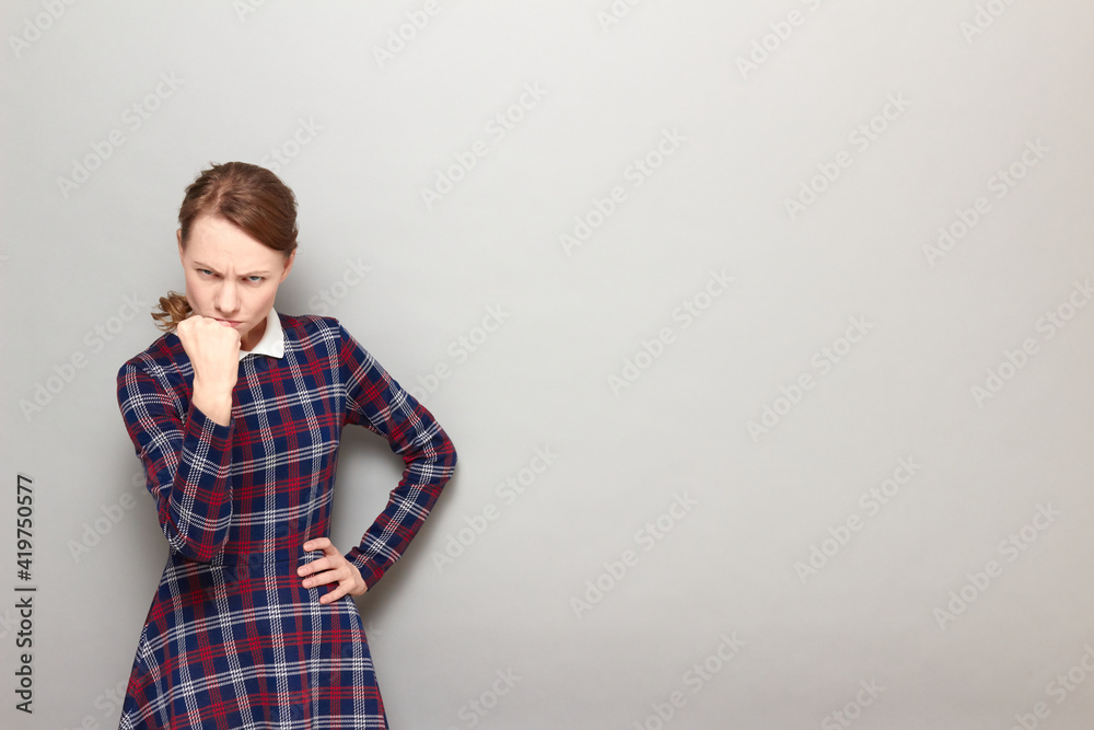 Portrait of funny angry girl shaking fist in threatening gesture Portrait of funny angry girl shaking fist in threatening gesture