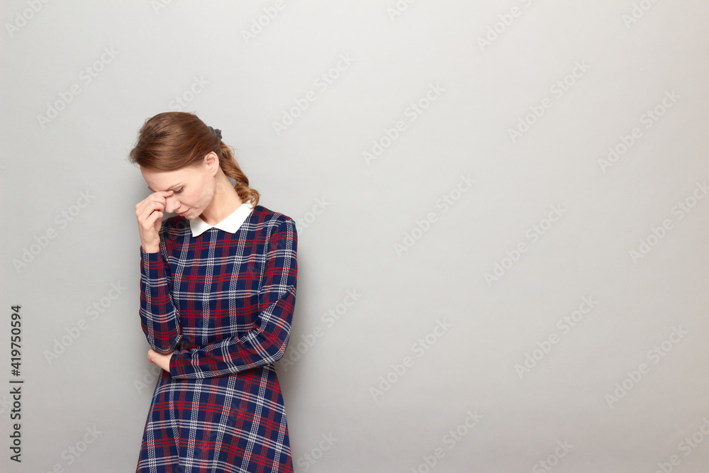 Portrait of thoughtful tired girl touching bridge of nose with hand Portrait of thoughtful tired girl touching bridge of nose with hand