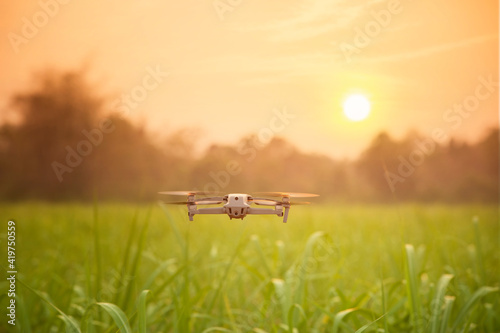 Drone flying over farmland with sunset background © ittipol