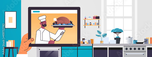 human watching african american chef food blogger preparing turkey on tablet screen online cooking concept kitchen interior portrait horizontal vector illustration