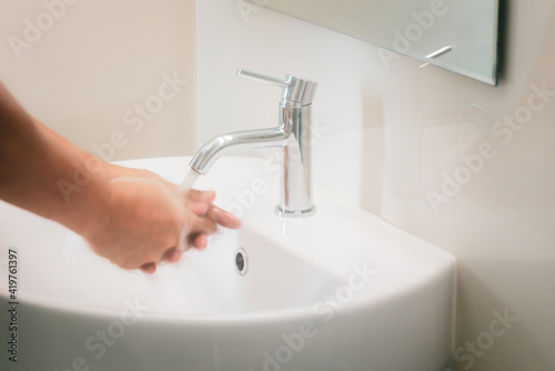 Soft focus of hands are joined together And catch the water from the faucet to wash hands, Concept of protection or prevention coronavirus or Covid19 by washing or cleaning hands frequently.