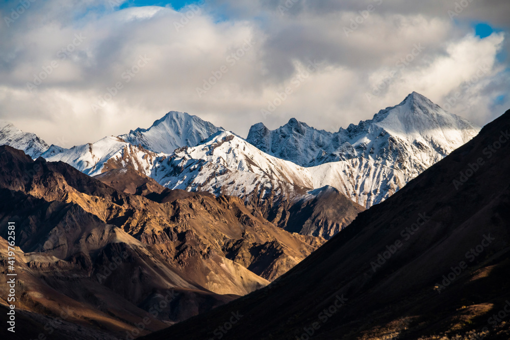 Fototapeta premium dramatic snow capped Alaskan mountain range inside the Denali National Park in Alaska taken during autumn.
