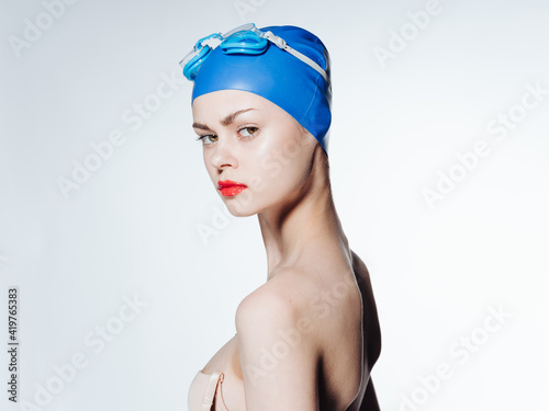 Beautiful woman with red lips blue swimming cap diving model