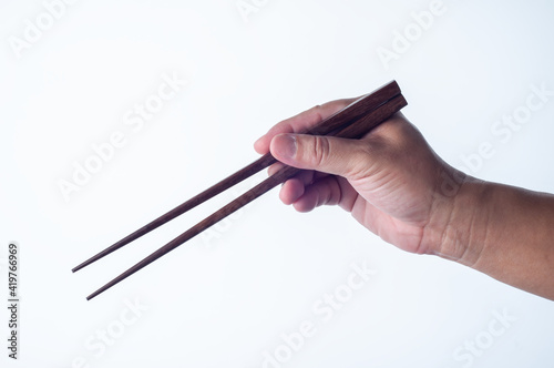 chopsticks in hand isolated on white background with clipping path