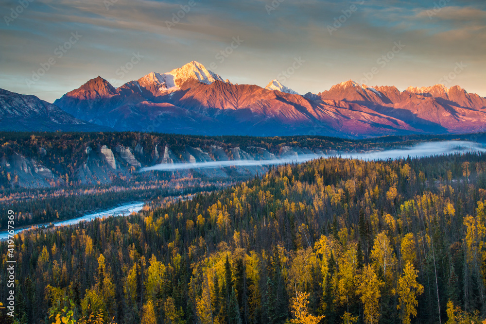 dramatic autumn sunrise in the  snow capped Chugach mountain range and Matanuska river  in Alaska.
