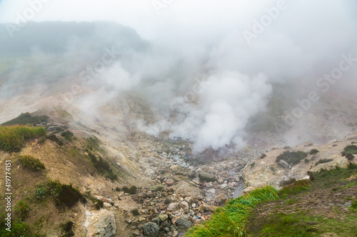 Mysterious view of volcanic landscape, aggressive hot spring, erupting fumarole, gas-steam activity in crater of active volcano. Beautiful mount landscape, travel destinations for hike, vacation.