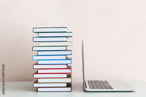 Stack of books and laptop o...