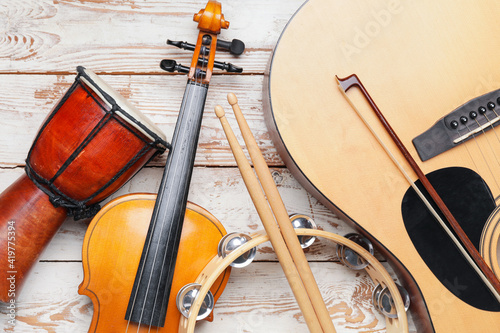 Different musical instruments on light wooden background, closeup