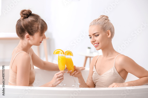 Happy lesbian couple drinki...