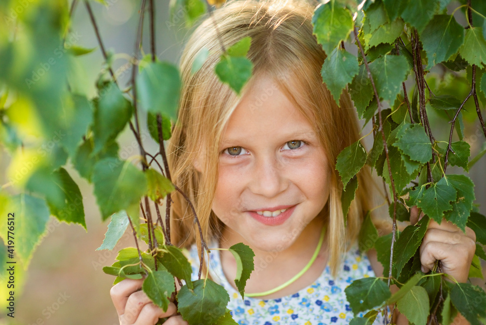 blonde girl portrait in green foliage, selective focus blonde girl portrait in green foliage, selective focus