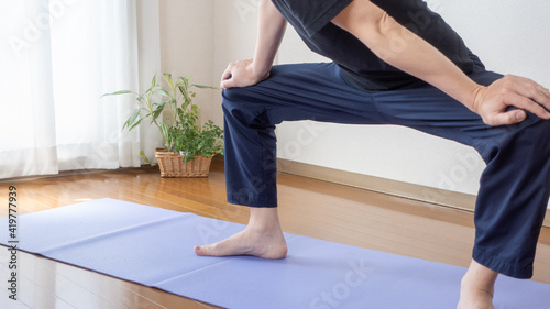 A man stretching at home. Stretched legs:Open legs:Hamstring stretch