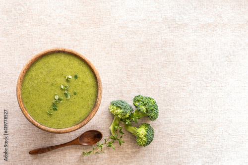 Foto Food background with broccoli soup in wooden bowl over cotton fabric surface