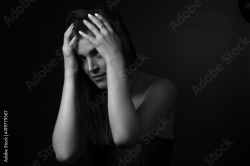 black and white portrait of an adult woman in a studio on a black background.