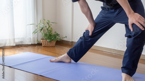 A man stretching at home. Stretched legs:Open legs:Hamstring stretch