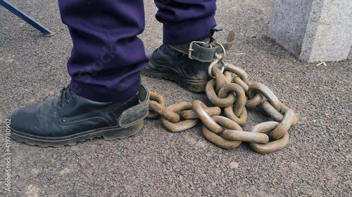 Shallow depth of field (selective focus) details of a policeman who tied a rusty metal chain to his feet during a protest in Bucharest.