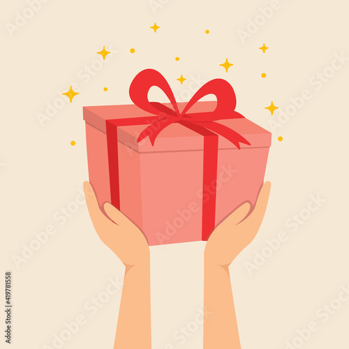 Hand holding gift box with red ribbon for special day 