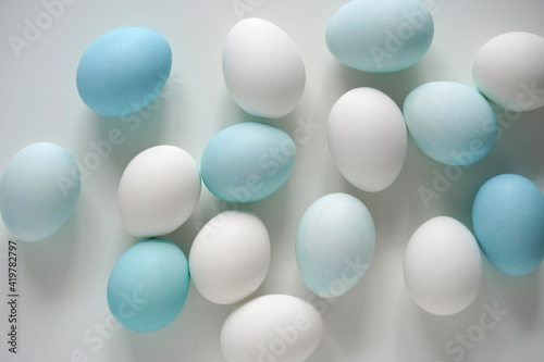 White and blue Easter eggs on white table. Soft light soft colors. Top view. Easter background concept