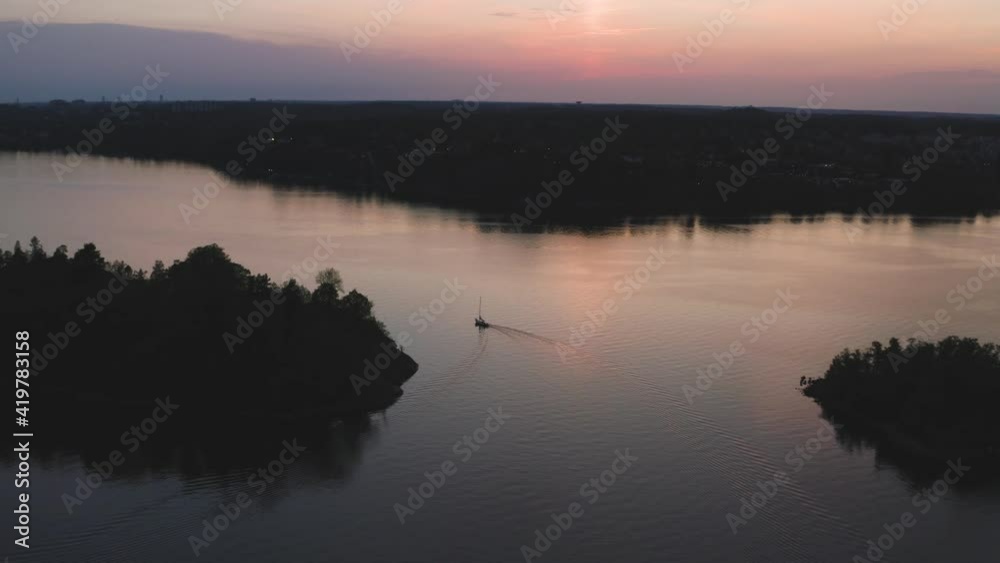 Lone boat sailing through Stockholm skerries late in summers night. Aerial wide shot. Lone boat sailing through Stockholm skerries late in summers night. Aerial wide shot.