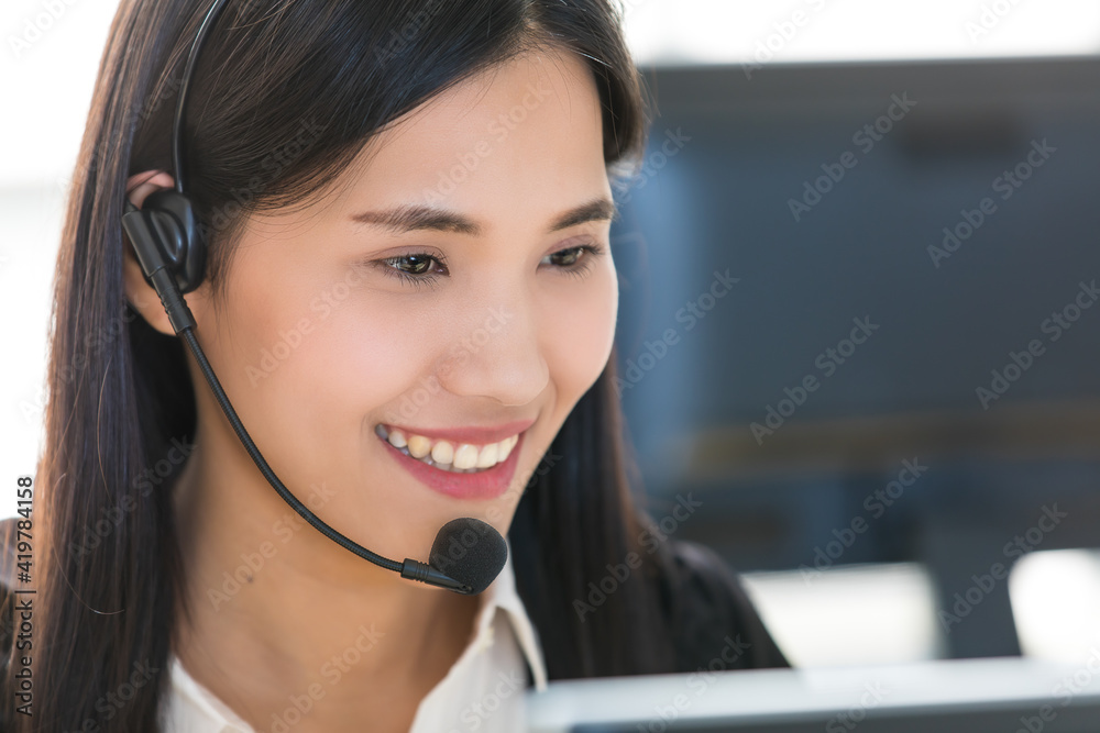 Young and beautiful Asian woman call center officer wearing microphone headset and happy working with a friendly face and positive service mind Young and beautiful Asian woman call center officer wearing microphone headset and happy working with a friendly face and positive service mind