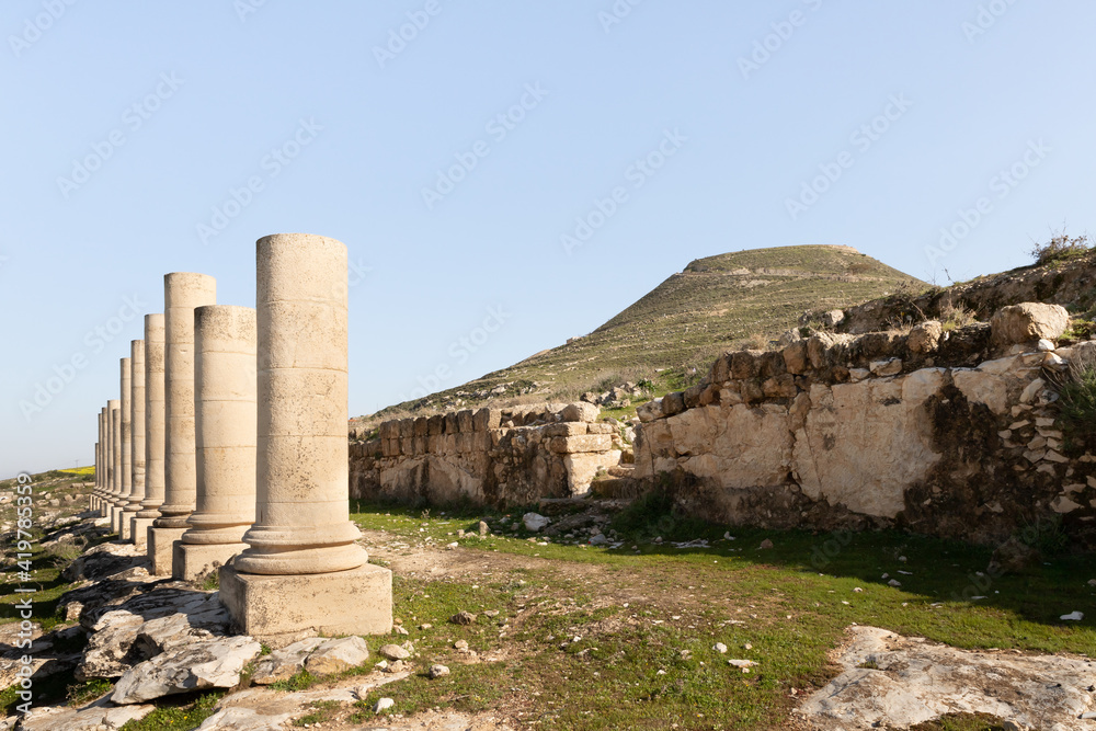 The remains  of columns in ruins of palace of King Herod - Herodion, against background of filled artificial hill in which they are located palace of King Herod - Herodion, in Judean Desert, in Israel