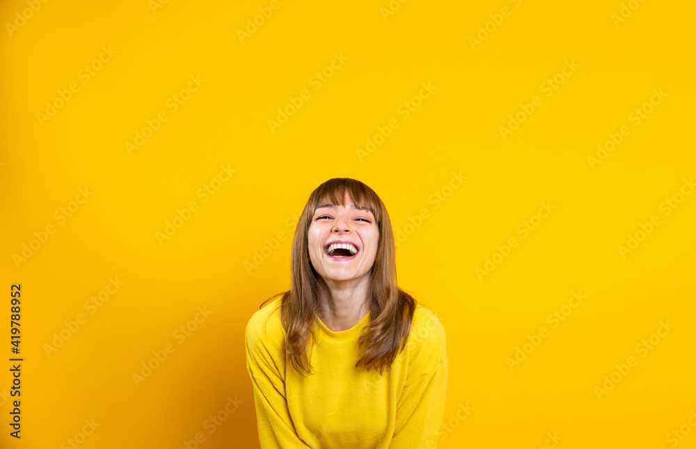 Portrait of happy young woman smiling at camera isolated on bright yellow background Portrait of happy young woman smiling at camera isolated on bright yellow background