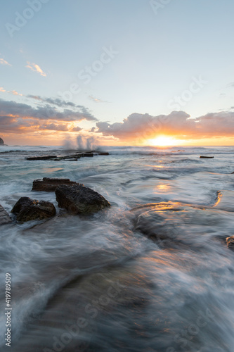 Seawater flowing on the shore at sunrise time.