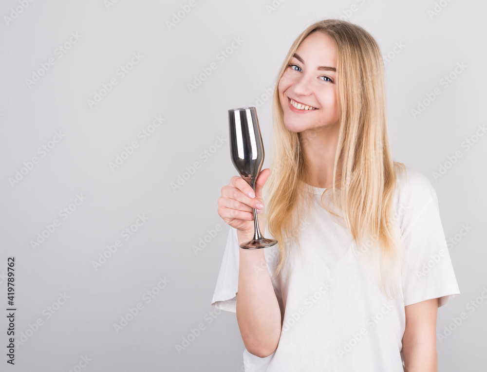 Portrait of beautiful young woman with long blond hair wearing white tank top posing with glass of champagne, isolated on white background Portrait of beautiful young woman with long blond hair wearing white tank top posing with glass of champagne, isolated on white background