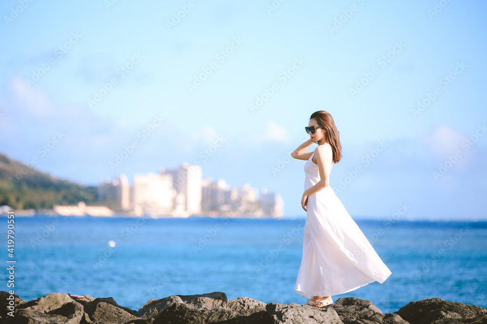 Girl wearing white long dress by the sea, Honolulu, Oahu, Hawaii