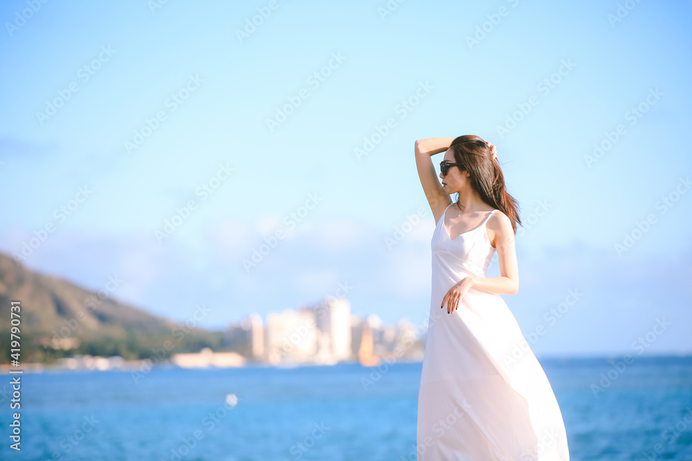 Girl wearing white long dress by the sea, Honolulu, Oahu, Hawaii Girl wearing white long dress by the sea, Honolulu, Oahu, Hawaii