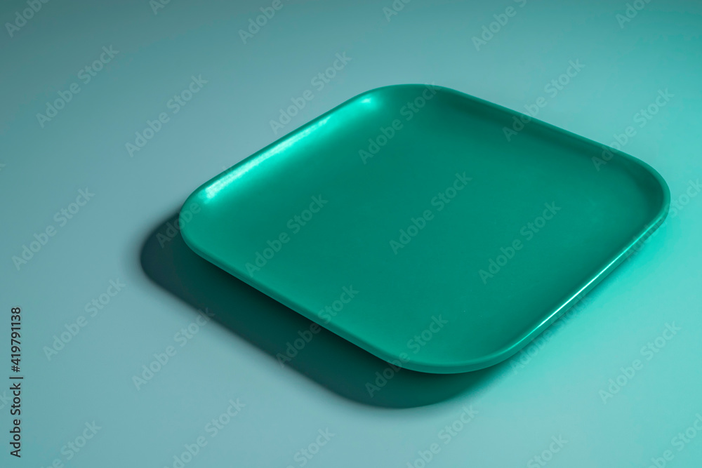 Empty emerald tray over blue background. Empty emerald tray over blue background.