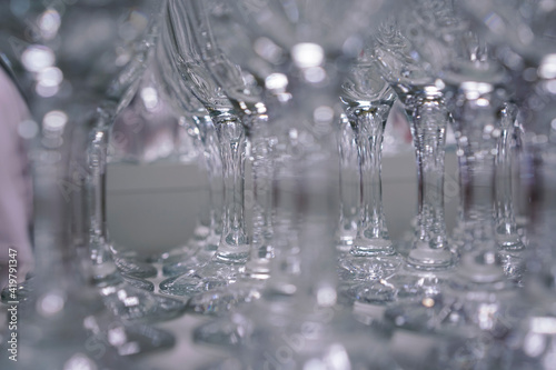 glasses stand in a row and glare in the light at a cocktail party