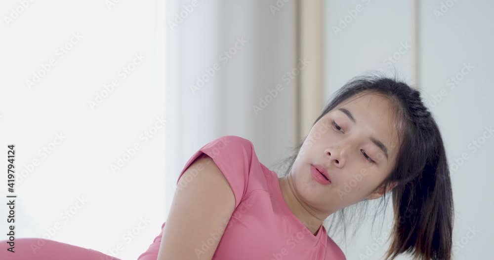 Face close up Asian woman side leg muscle warm up workout weight training exercise at home in sportswear Face close up Asian woman side leg muscle warm up workout weight training exercise at home in sportswear