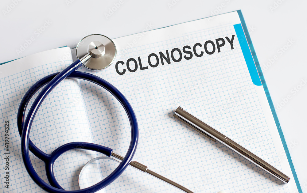 Paper with text COLONOSCOPY on a table with stethoscope Paper with text COLONOSCOPY on a table with stethoscope