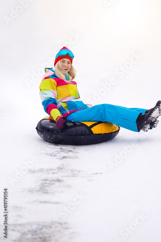 Wintersport Activities. Lovely Caucasian Girl Having Tube Activities In Winter Time And Sliding Downhill In Mountains.