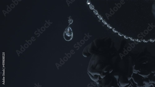 Set of diamond earrings and pendant moving on black background