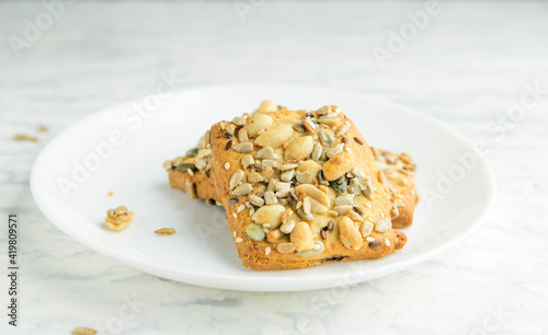 Homemade cookies with cereals and nuts on a marble table.