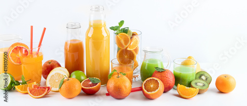 Raw fresh citrus juices and fruints in glasses and bottles