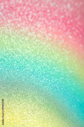 Sparkling glitter vertical background. Abstract texture of shiny grainy paper with gradient pink  green and yellow dusting