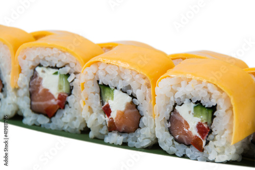 Rolls with salmon, chedar cheese, cream cheese, nori, cucumber and bell peppers, over white plate with copy space.