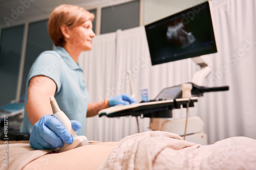 Doctor performing ultrasound procedure in modern clinic.