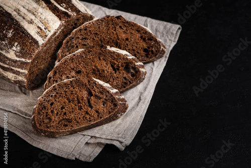 Obraz na płótnie Sliced rye bread. Artisan sourdough dark bread on black background. w salonie